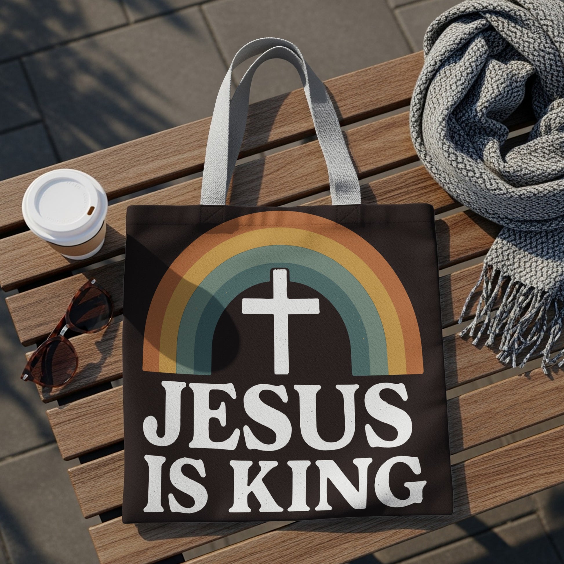 Dark tote bag with rainbow, cross, and text "JESUS IS KING"