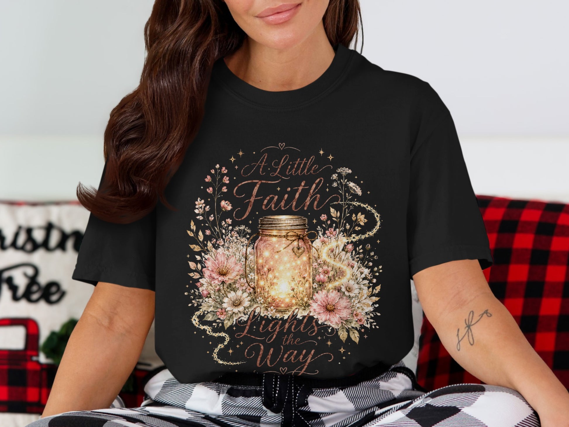 Black t-shirt featuring "A Little Faith Lights the Way" with a glowing jar and flowers.
