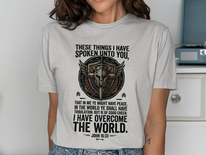 T-shirt with a shield graphic and the Bible verse John 16:33.