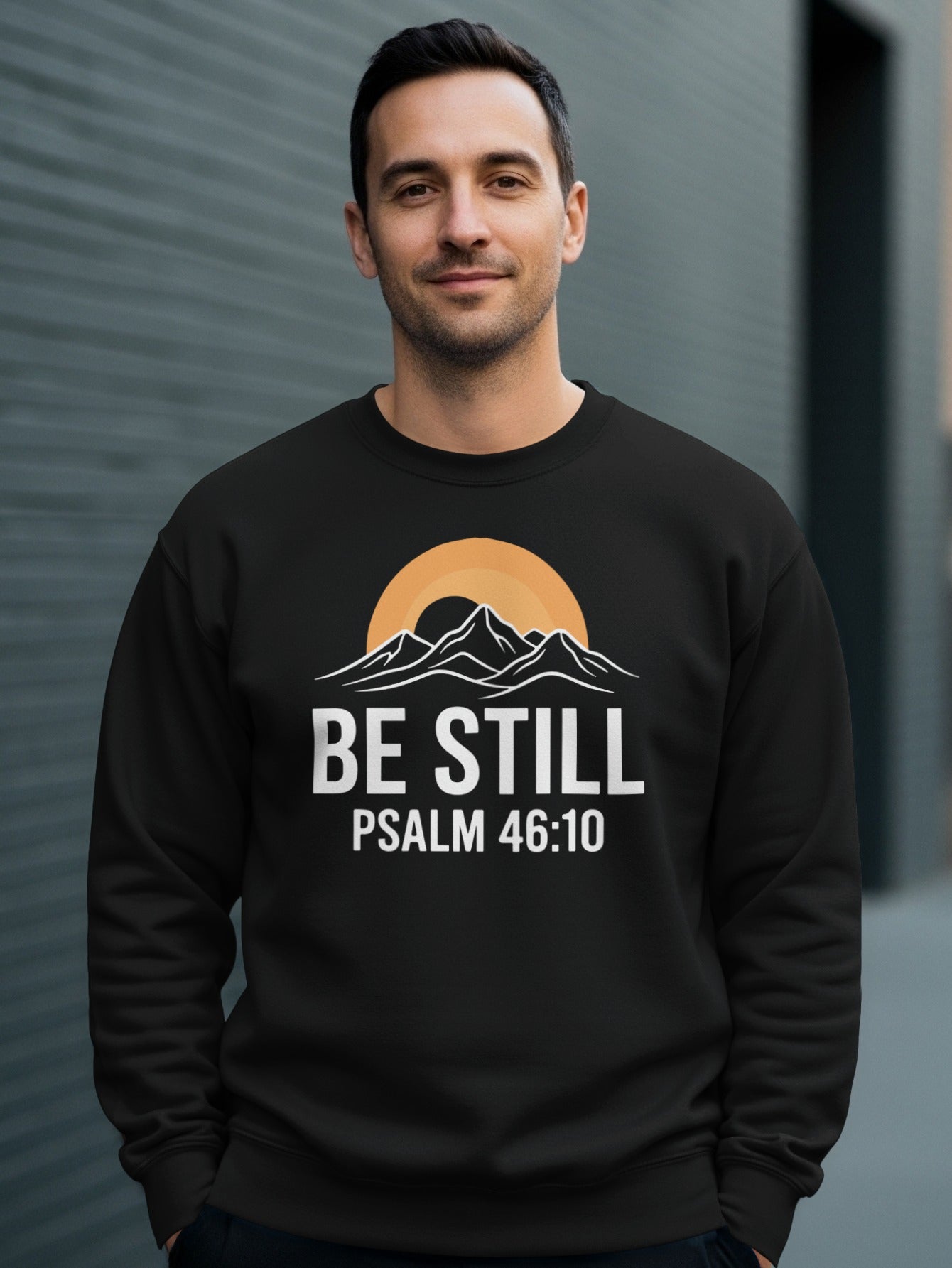 Black sweatshirt with "BE STILL PSALM 46:10" and mountain sunset graphic.