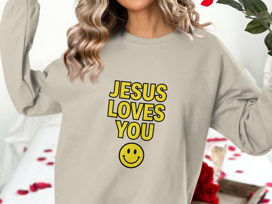 Cream sweatshirt with yellow "JESUS LOVES YOU" text and smiley face.