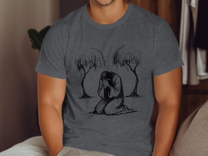 Man in charcoal t-shirt with line drawing of figure kneeling between two trees.