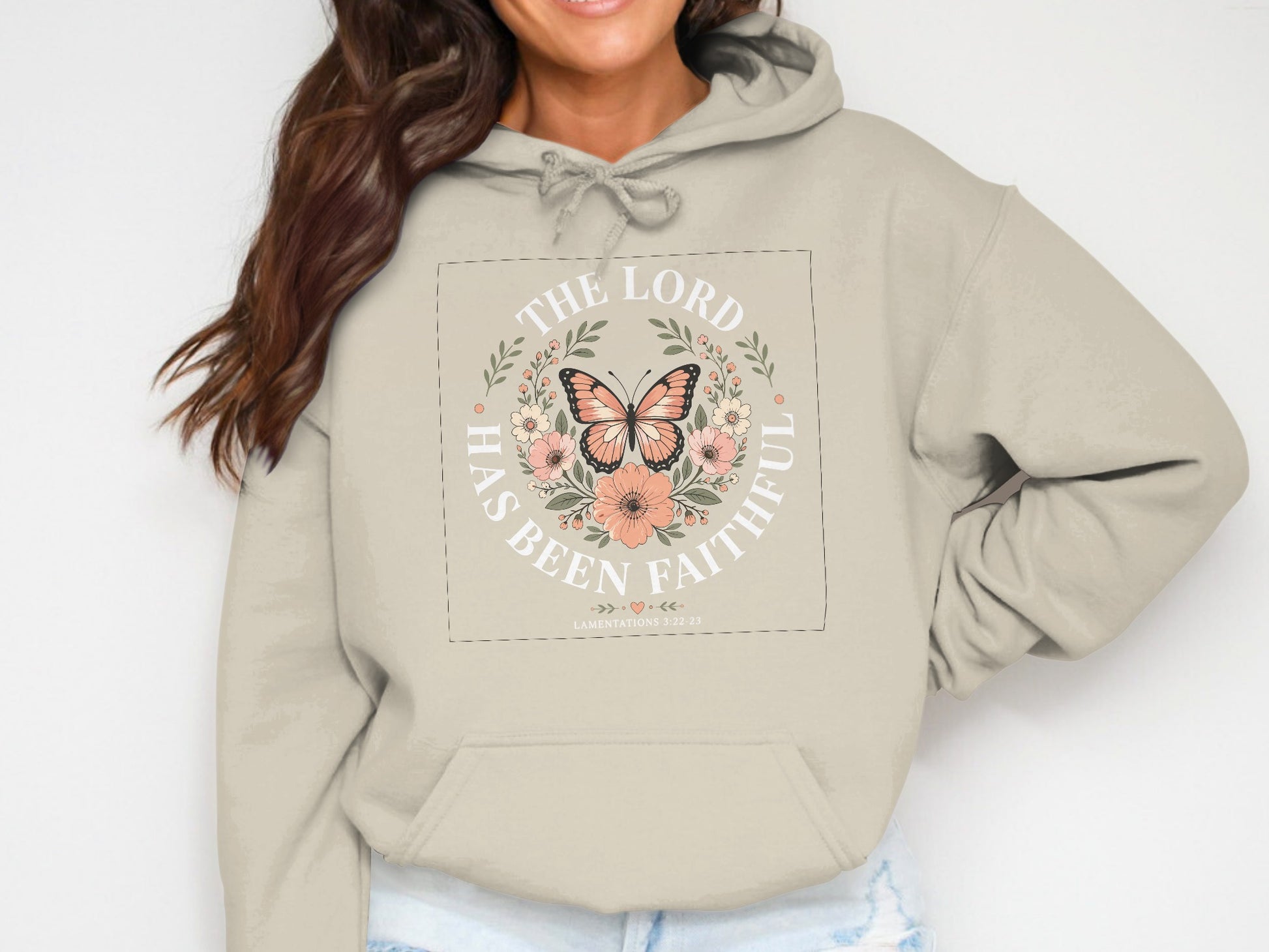 Cream hoodie with "The Lord has been faithful" text and floral butterfly graphic.