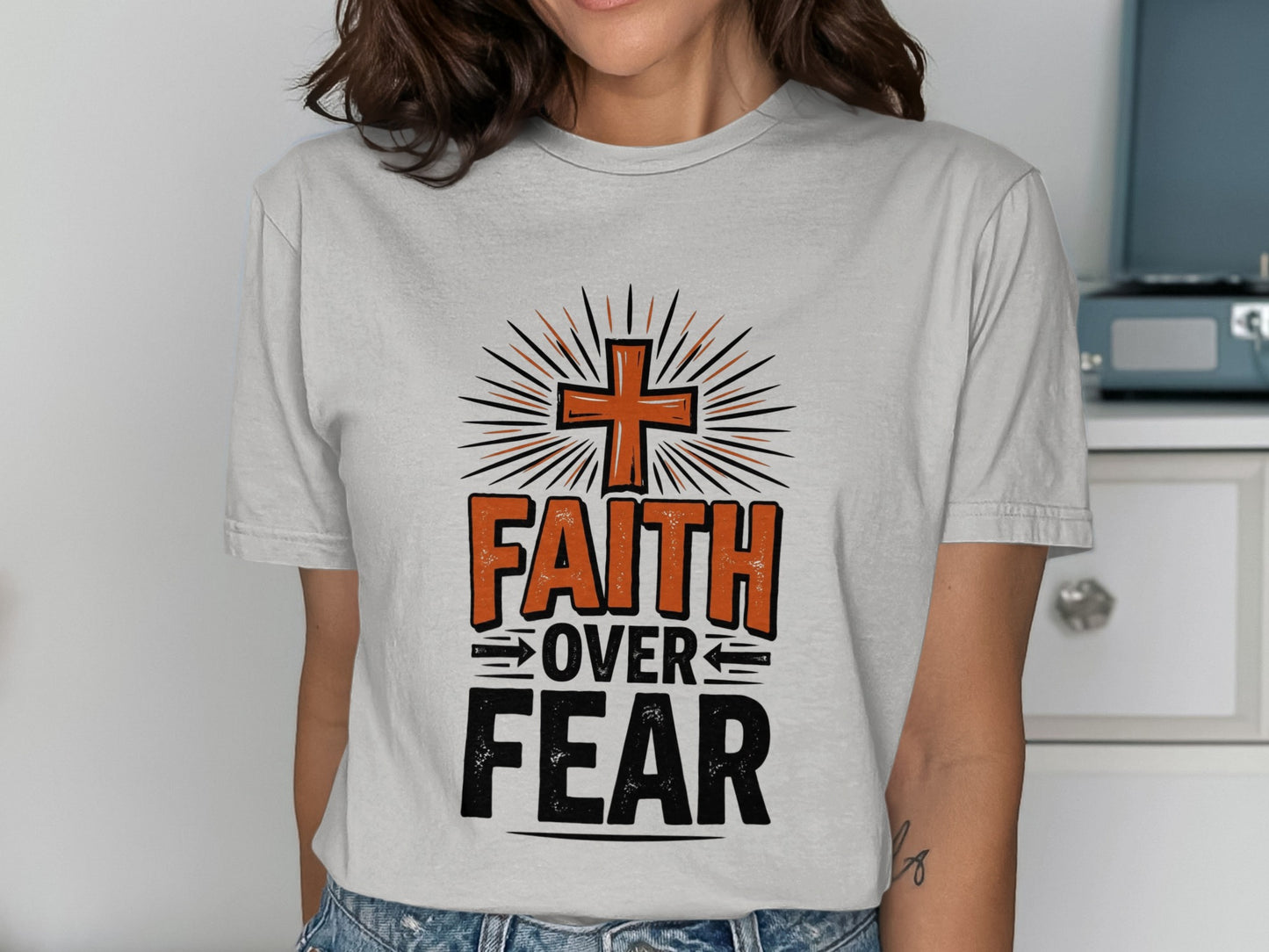 T-shirt with orange cross, "FAITH OVER FEAR" text, and sunburst graphic.