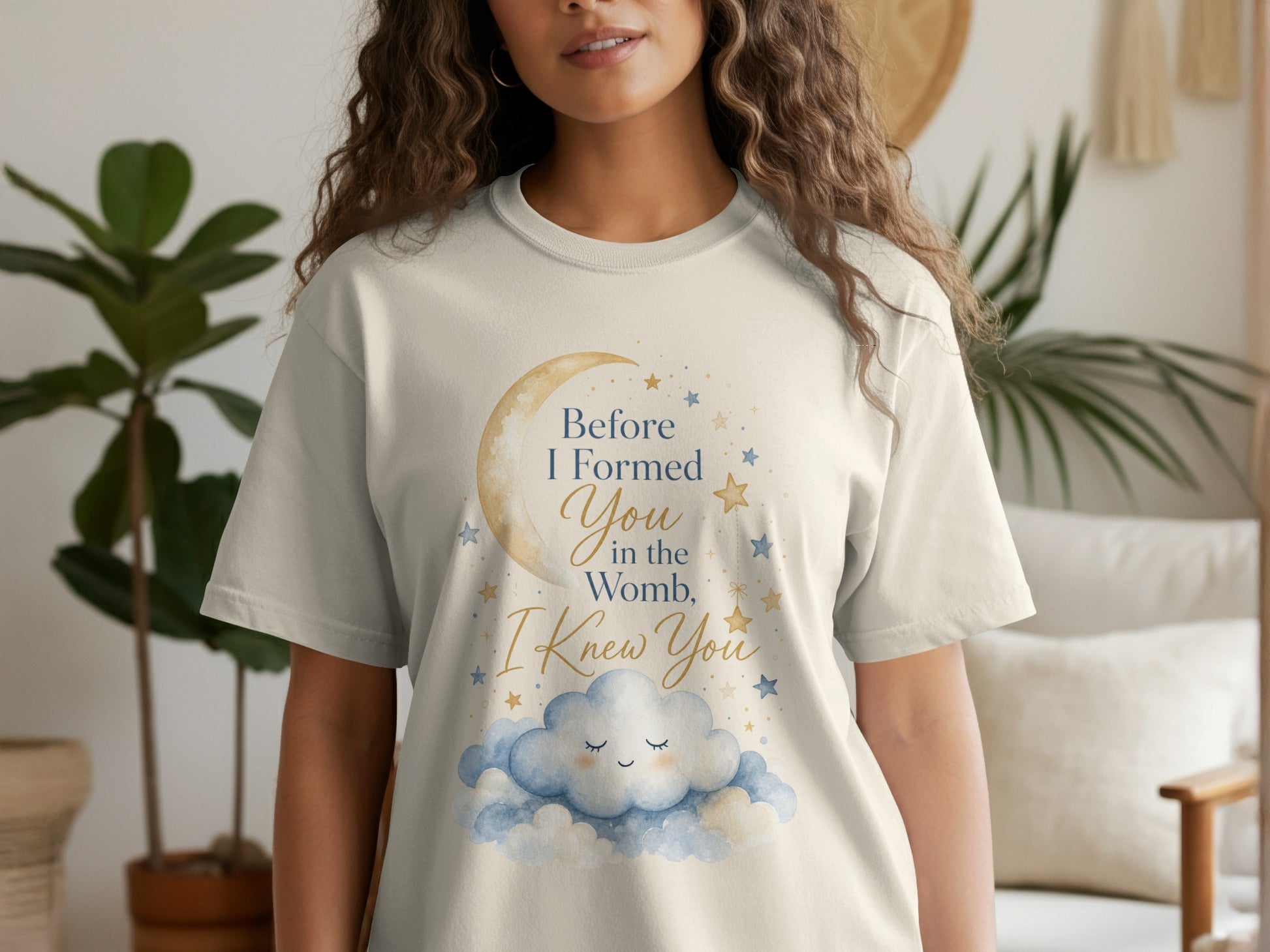 Cream t-shirt with text "Before I Formed You in the Womb, I Knew You" and celestial graphics.