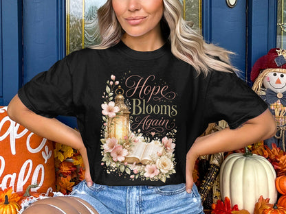 Black t-shirt with "Hope Blooms Again" text and floral lantern illustration.