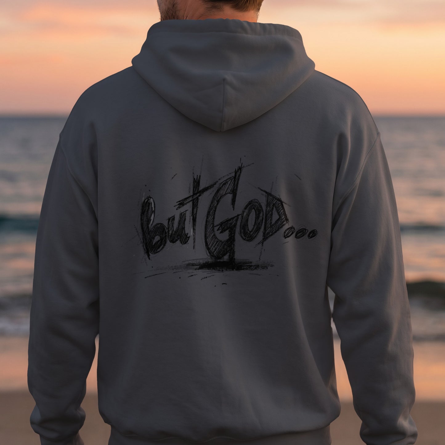 Back of gray hoodie with "but GOD..." graffiti text, person facing away from camera.