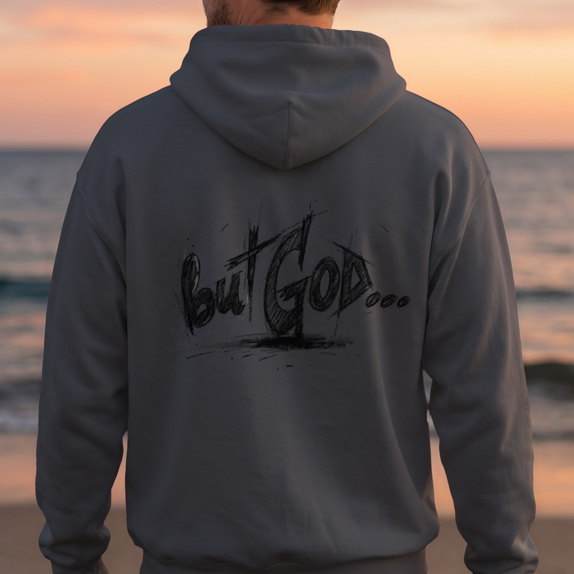 Back of gray hoodie with "but GOD..." graffiti text, person facing away from camera.