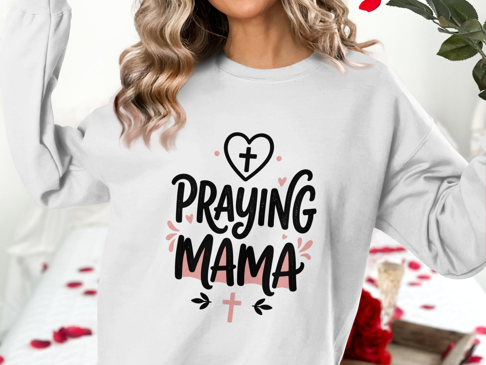 White sweatshirt with "Praying Mama" text and heart graphic.