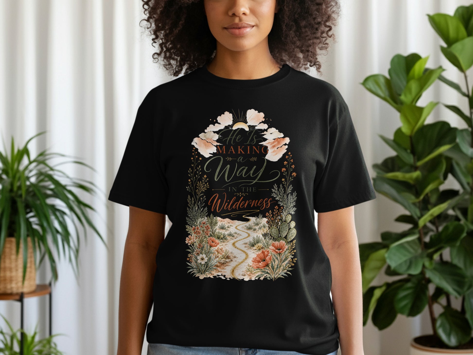 Black t-shirt with floral desert scene and text "He Is Making a Way In The Wilderness".