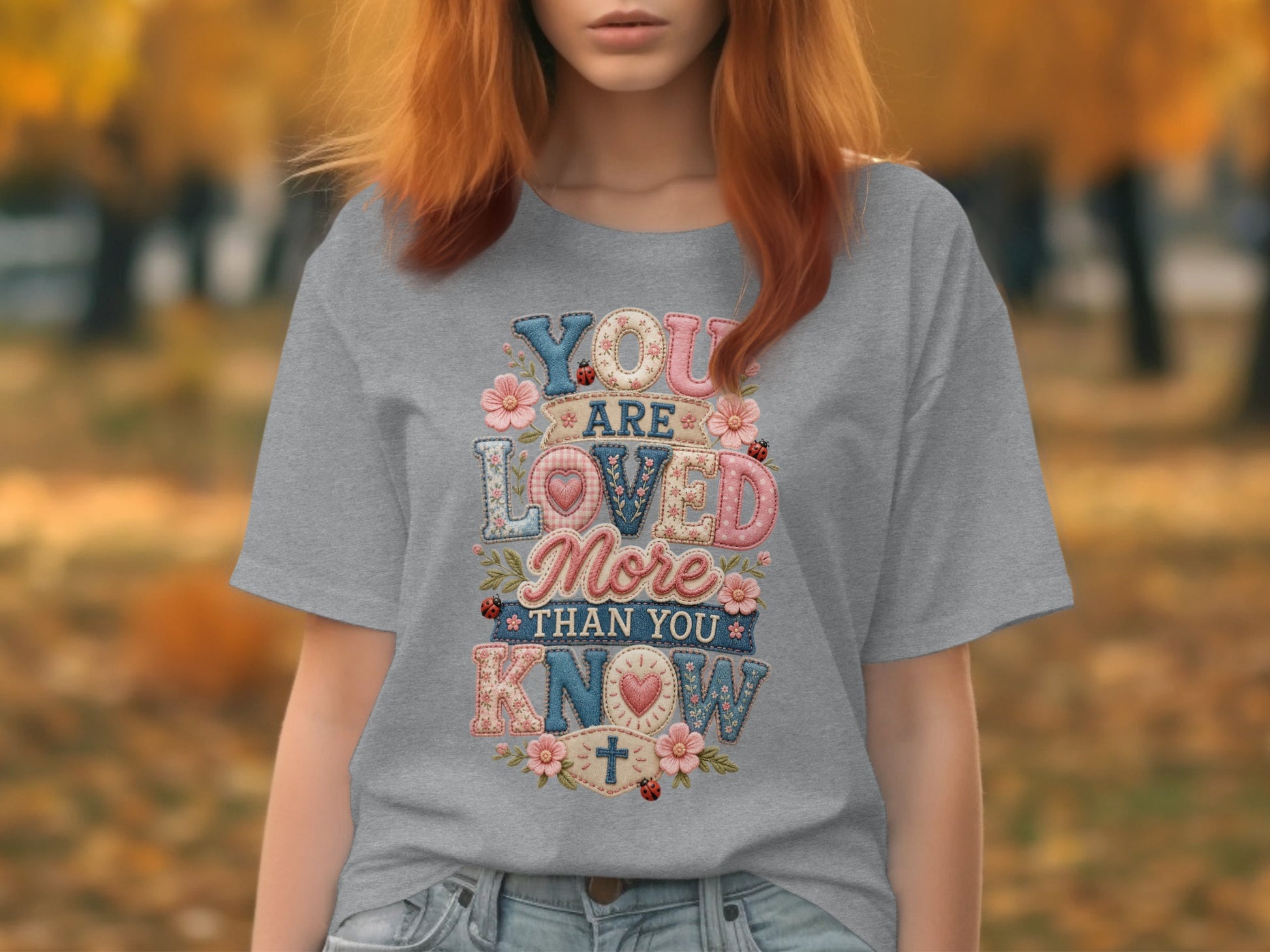 Gray t-shirt with "YOU ARE LOVED MORE THAN YOU KNOW" text in colorful patch style.