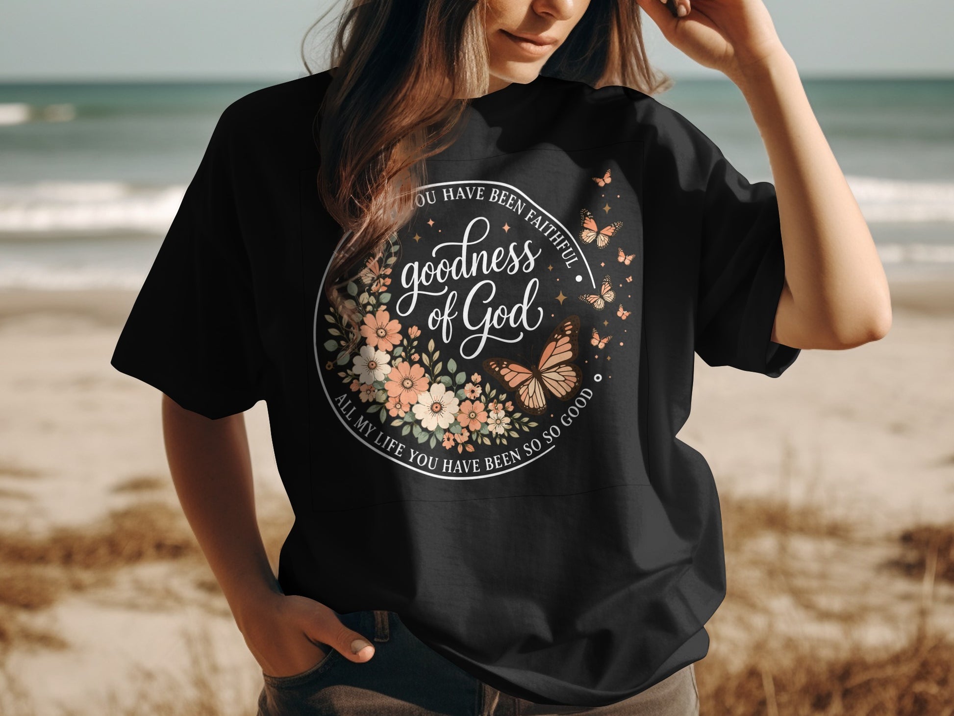 Black t-shirt with "Goodness of God" floral design and biblical quote.