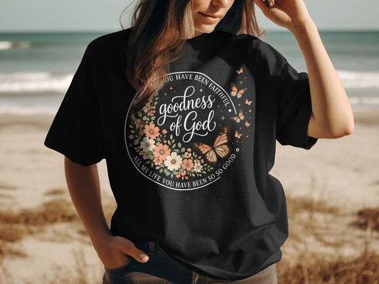 Black t-shirt with "Goodness of God" floral design and biblical quote.