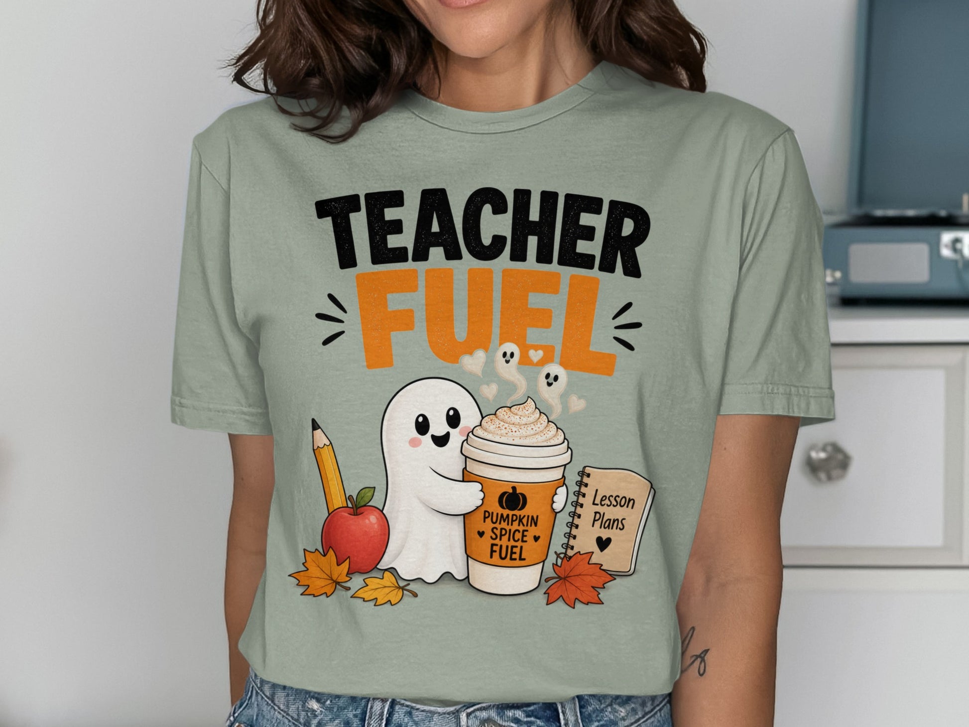 Teacher Fuel text with ghost holding pumpkin spice coffee, apple, pencil, and lesson plans.