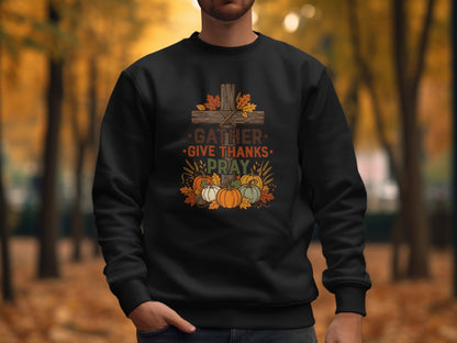 Black sweatshirt with fall-themed graphic: cross, pumpkins, leaves, and text "GATHER GIVE THANKS PRAY".
