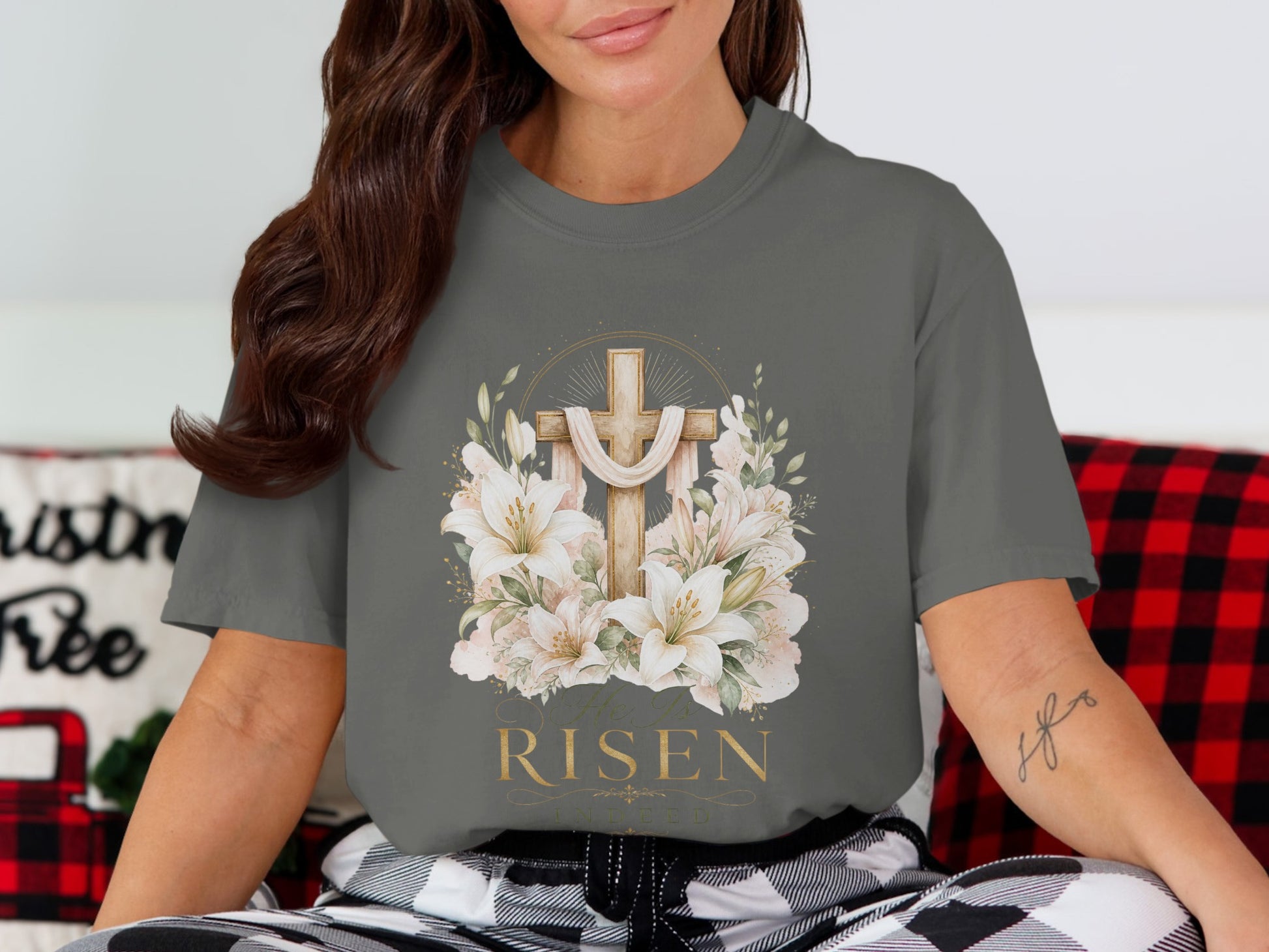 A gray t-shirt with a wooden cross, lilies, and the text "He is RISEN Indeed".
