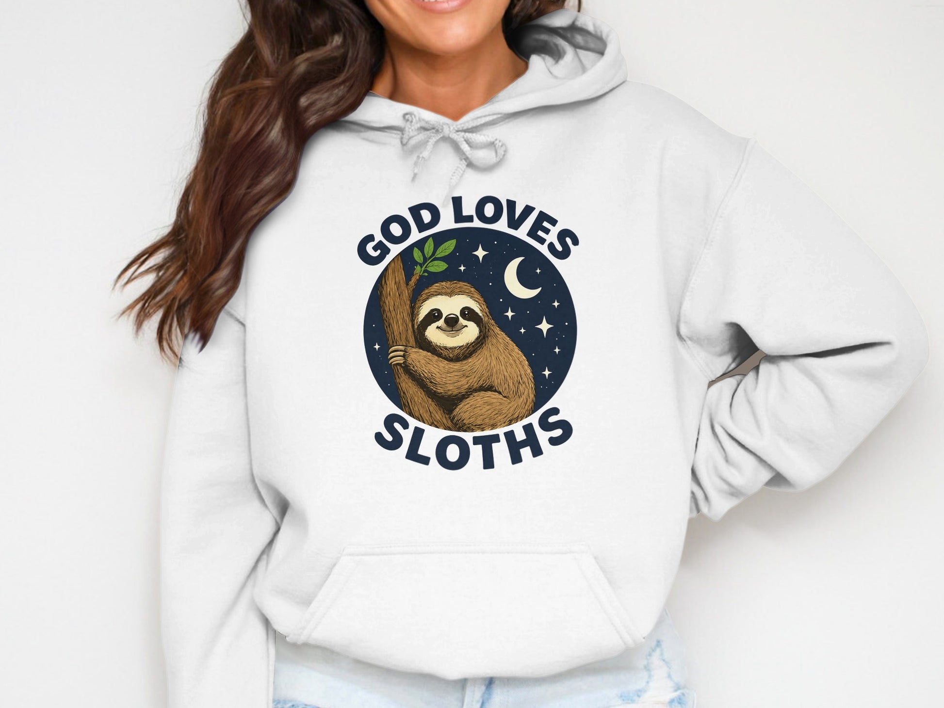 White hoodie with a graphic of a sloth holding a branch, saying "God Loves Sloths".