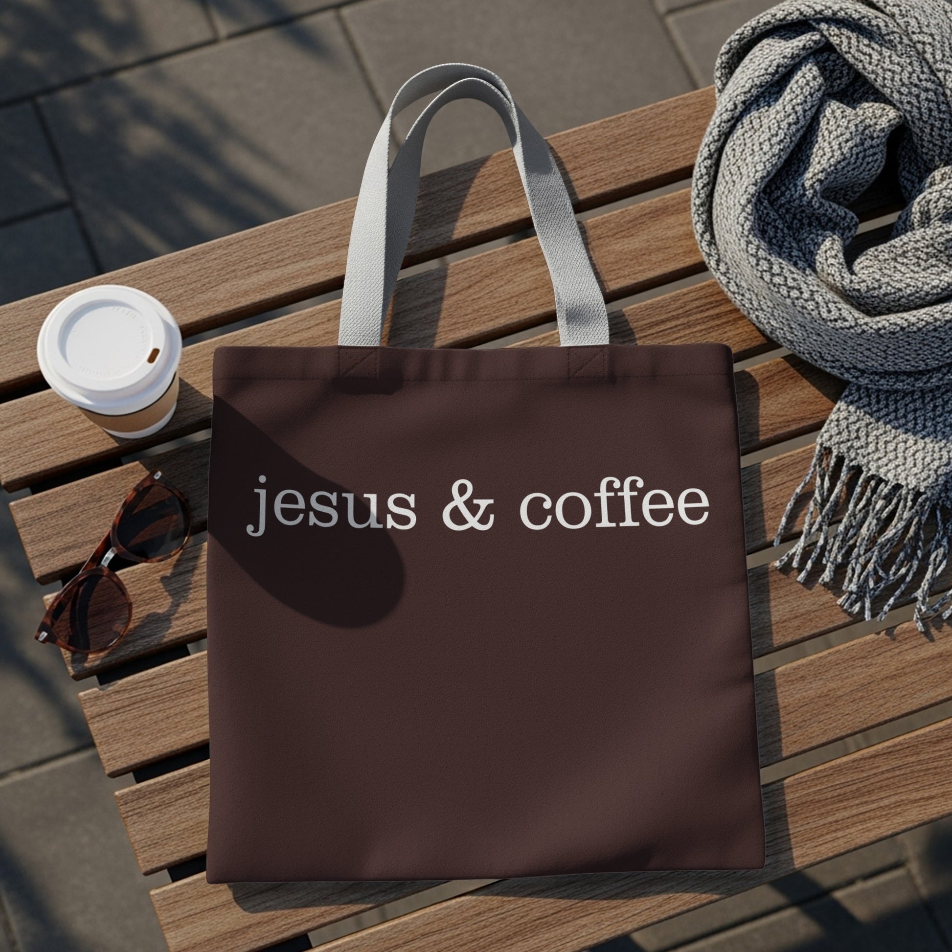 Brown tote bag with "jesus & coffee" text, sunglasses, coffee cup, and scarf.