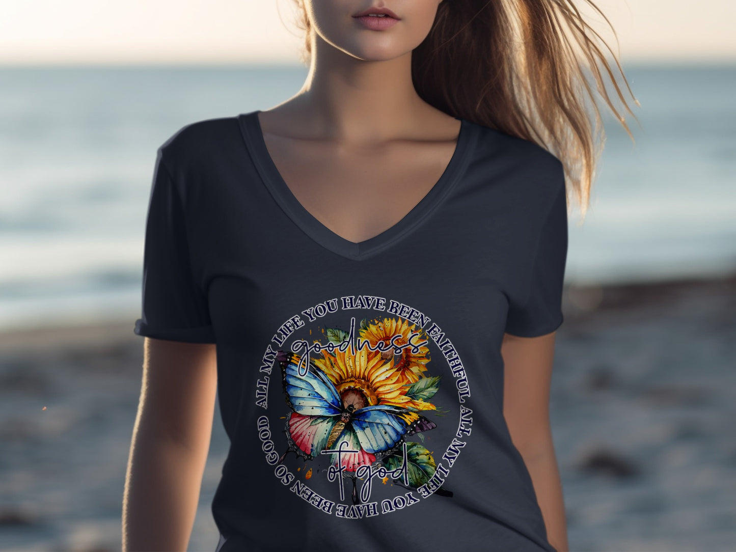 Woman wearing navy t-shirt with sunflower and butterfly graphic.