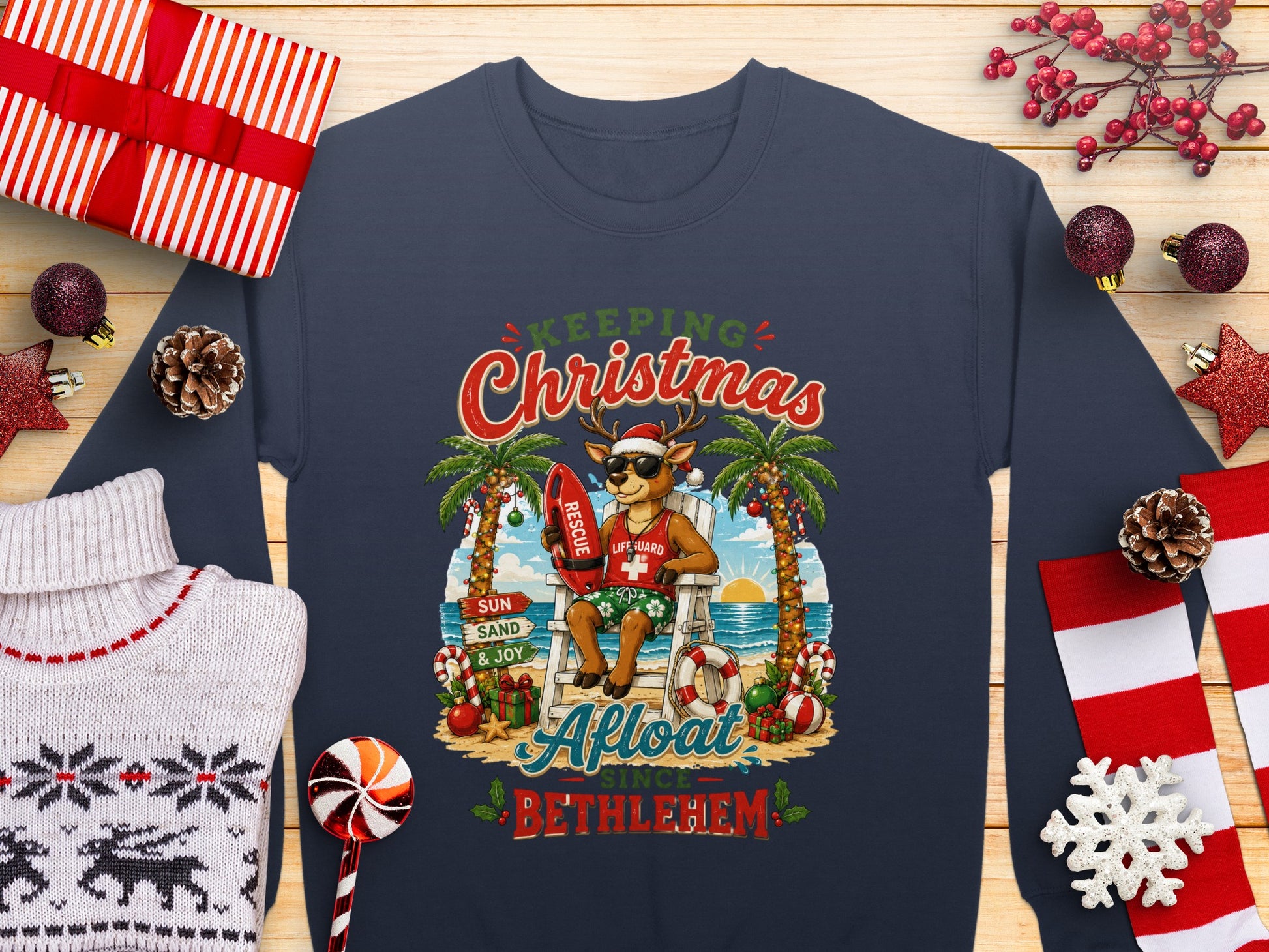 Deer in a lifeguard chair on a beach, wearing a Christmas sweater.