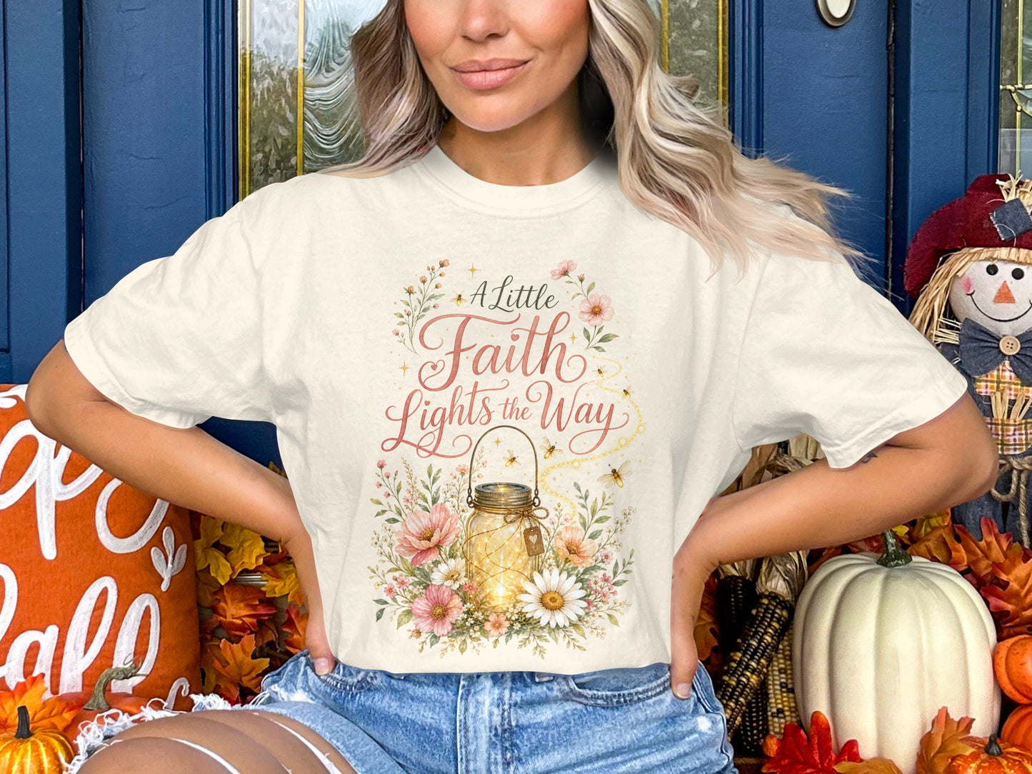 Cream t-shirt with "A Little Faith Lights the Way" text and floral design.