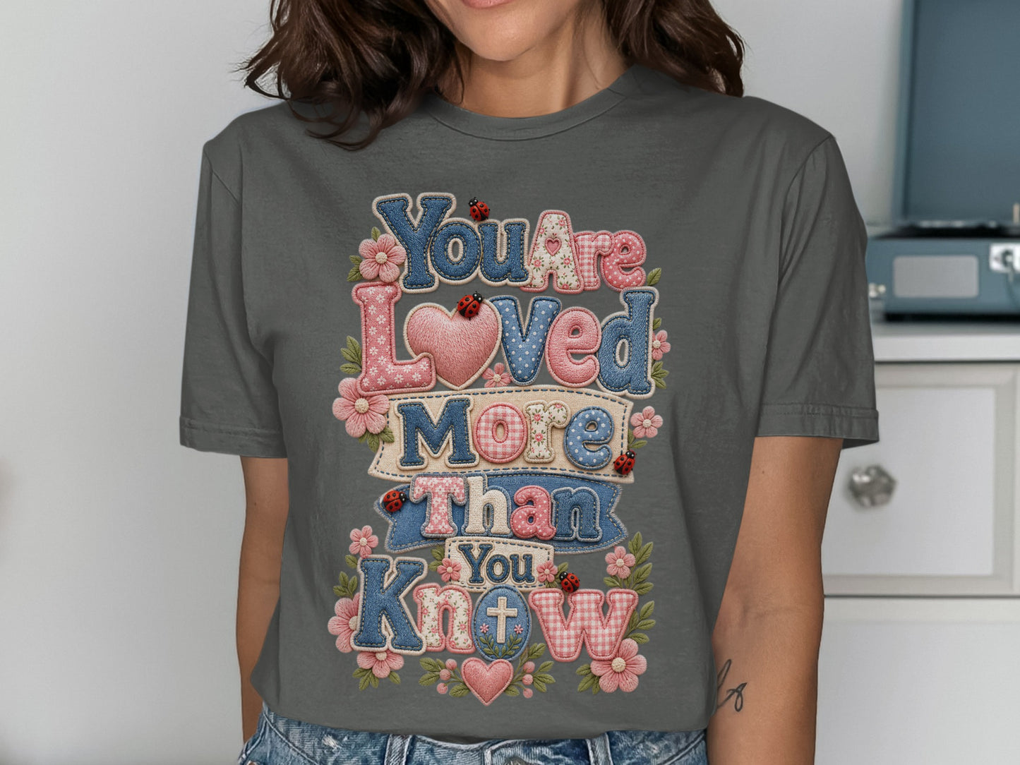 Dark grey t-shirt with "You Are Loved More Than You Know" text.