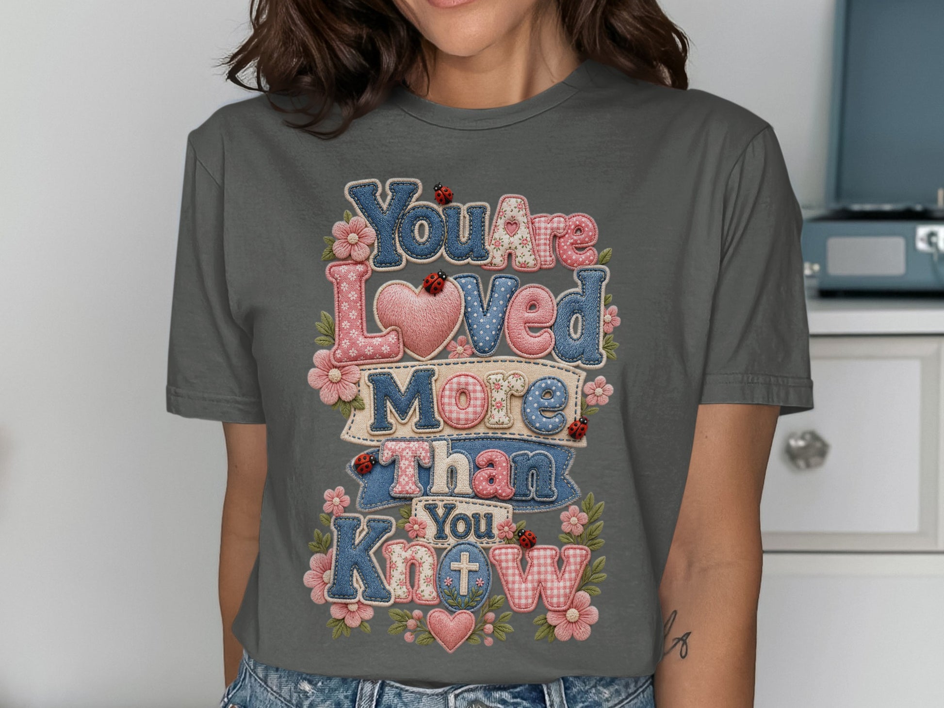 Dark grey t-shirt with "You Are Loved More Than You Know" text.