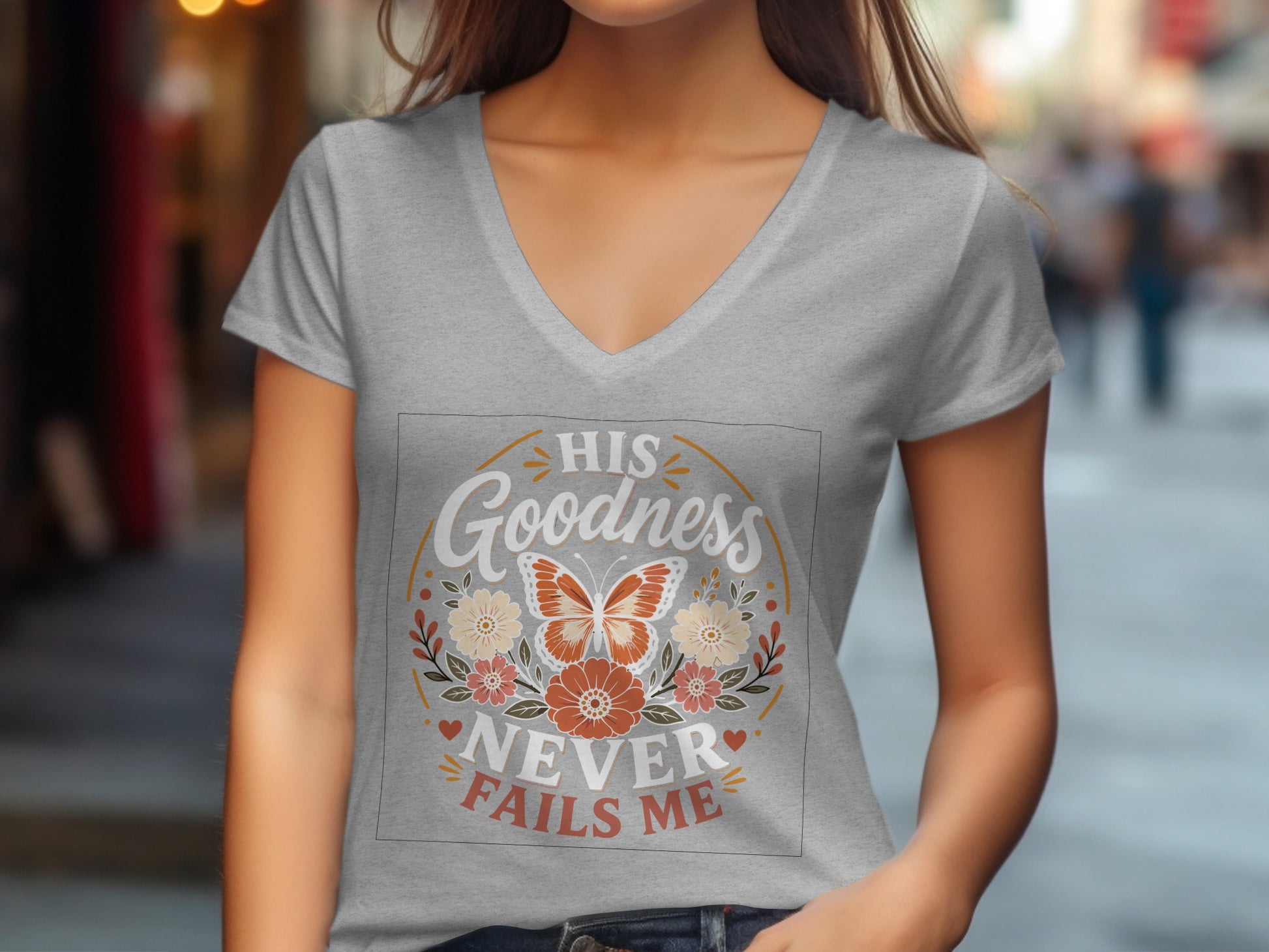 Grey v-neck t-shirt with butterfly and floral design, text reads "His Goodness Never Fails Me".