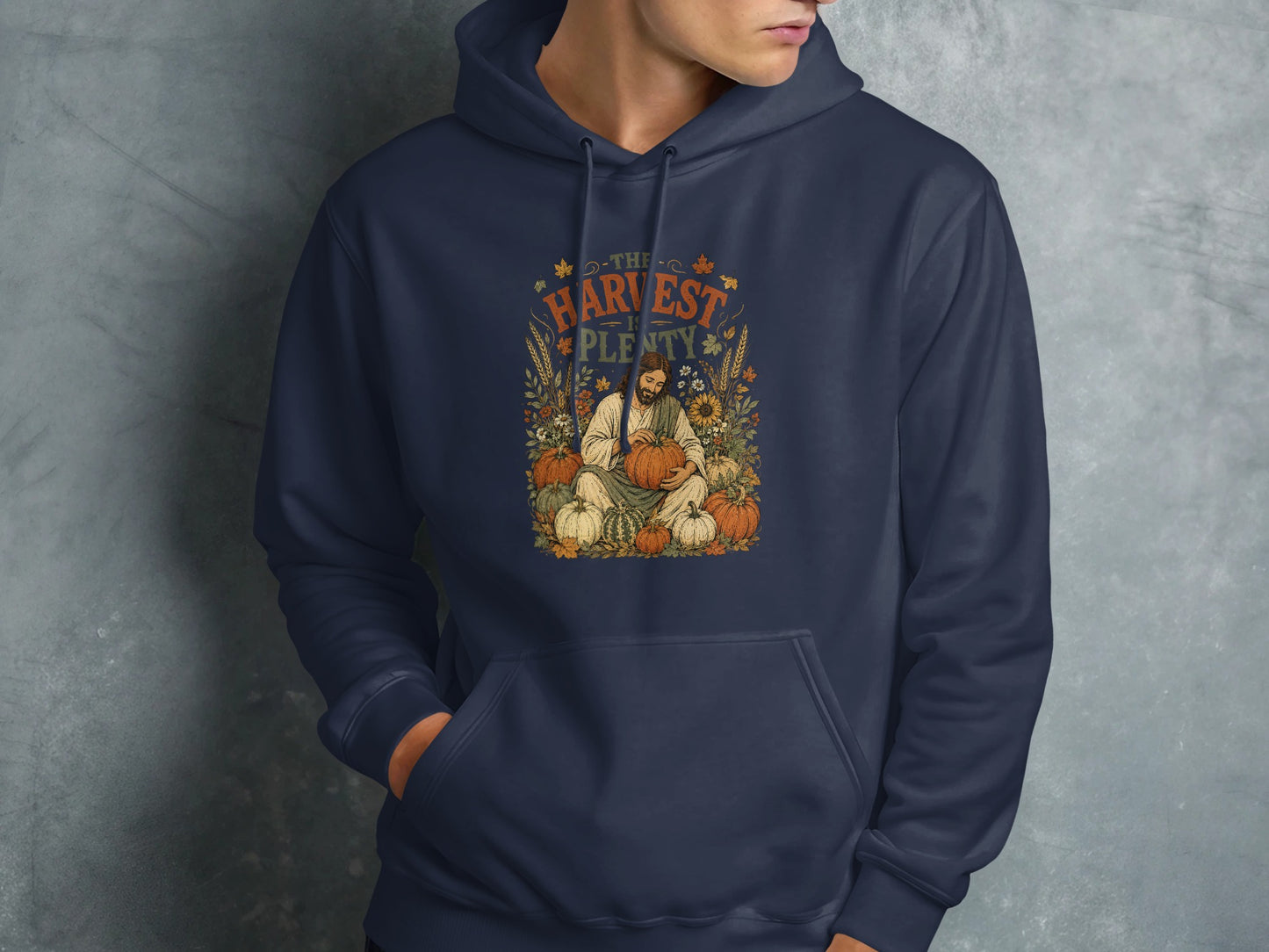 Navy hoodie featuring "The Harvest is Plenty" text and a man holding pumpkins.