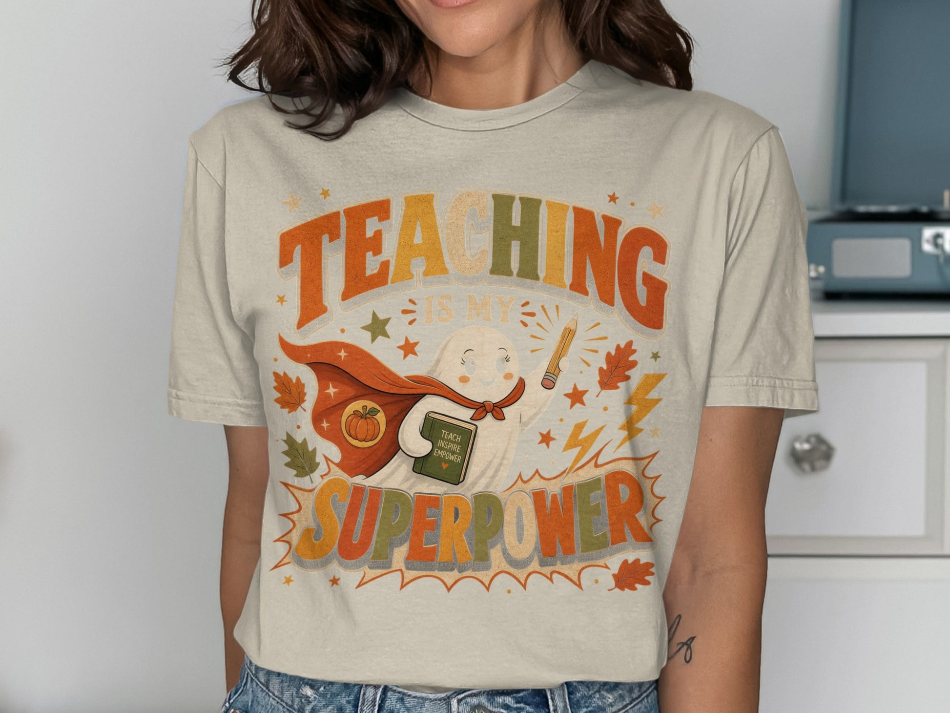 T-shirt graphic with text "TEACHING IS MY SUPERPOWER" and a cartoon ghost.