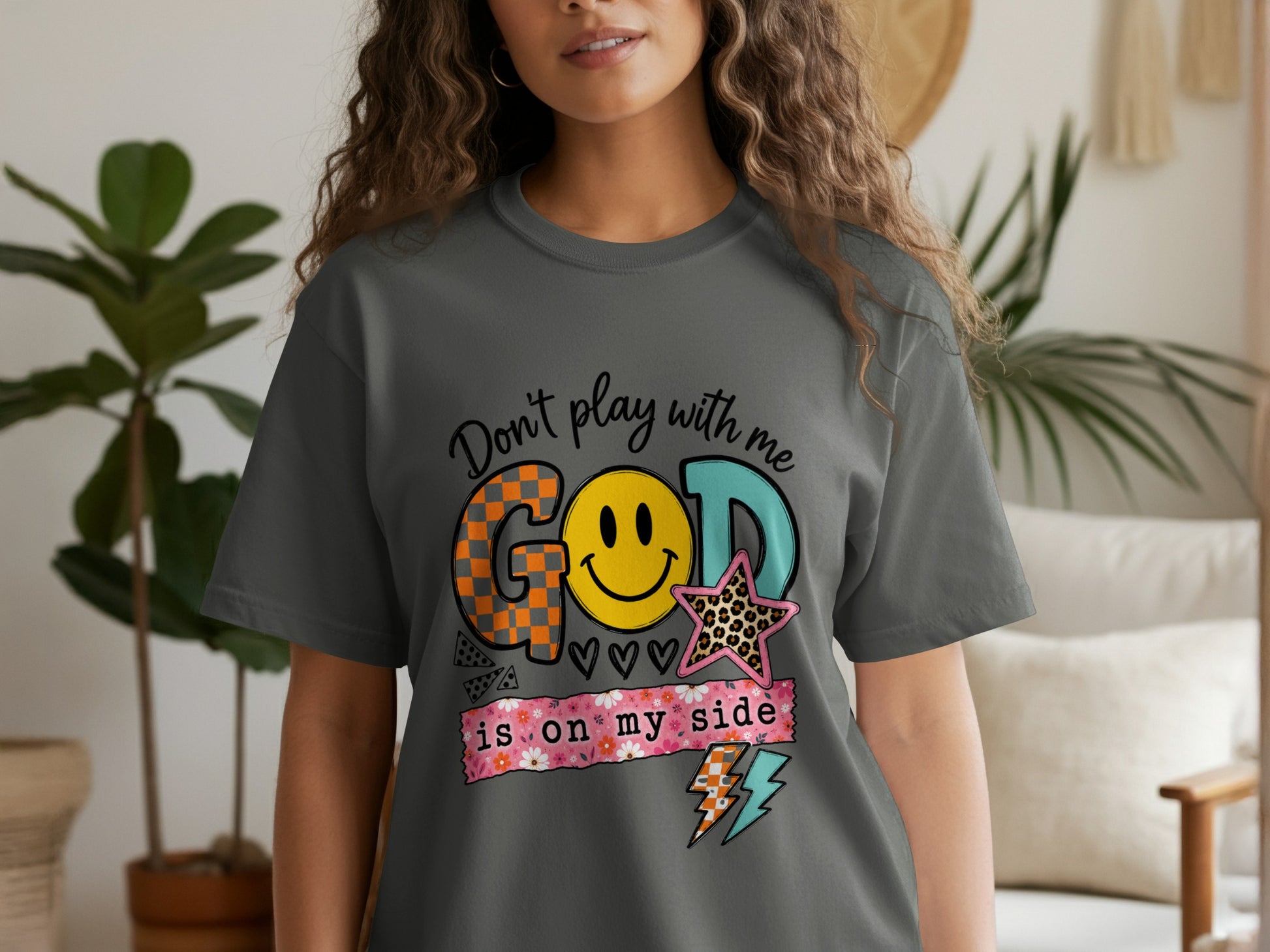 T-shirt with "Don't play with me, GOD is on my side" text and smiley face graphics.