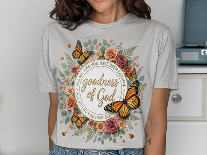 T-shirt with "goodness of God" text and floral butterfly design.