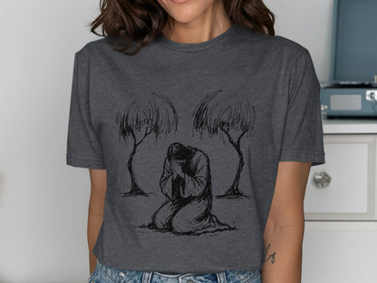Dark grey t-shirt featuring a line drawing of a person kneeling between two trees.