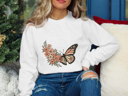White sweatshirt with butterfly and floral graphic and text.