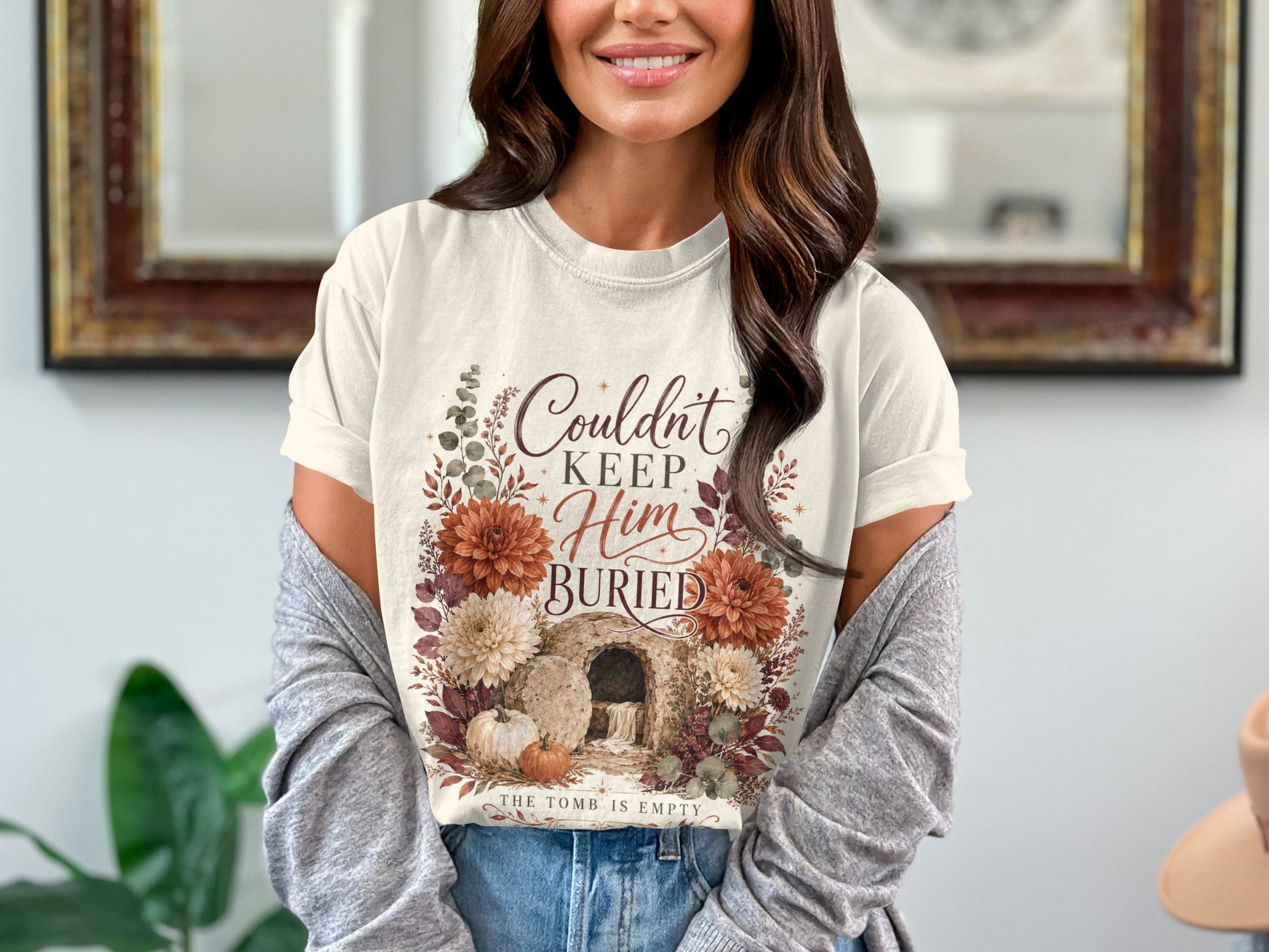 T-shirt with "Couldn't Keep Him Buried. The Tomb Is Empty" and floral design.