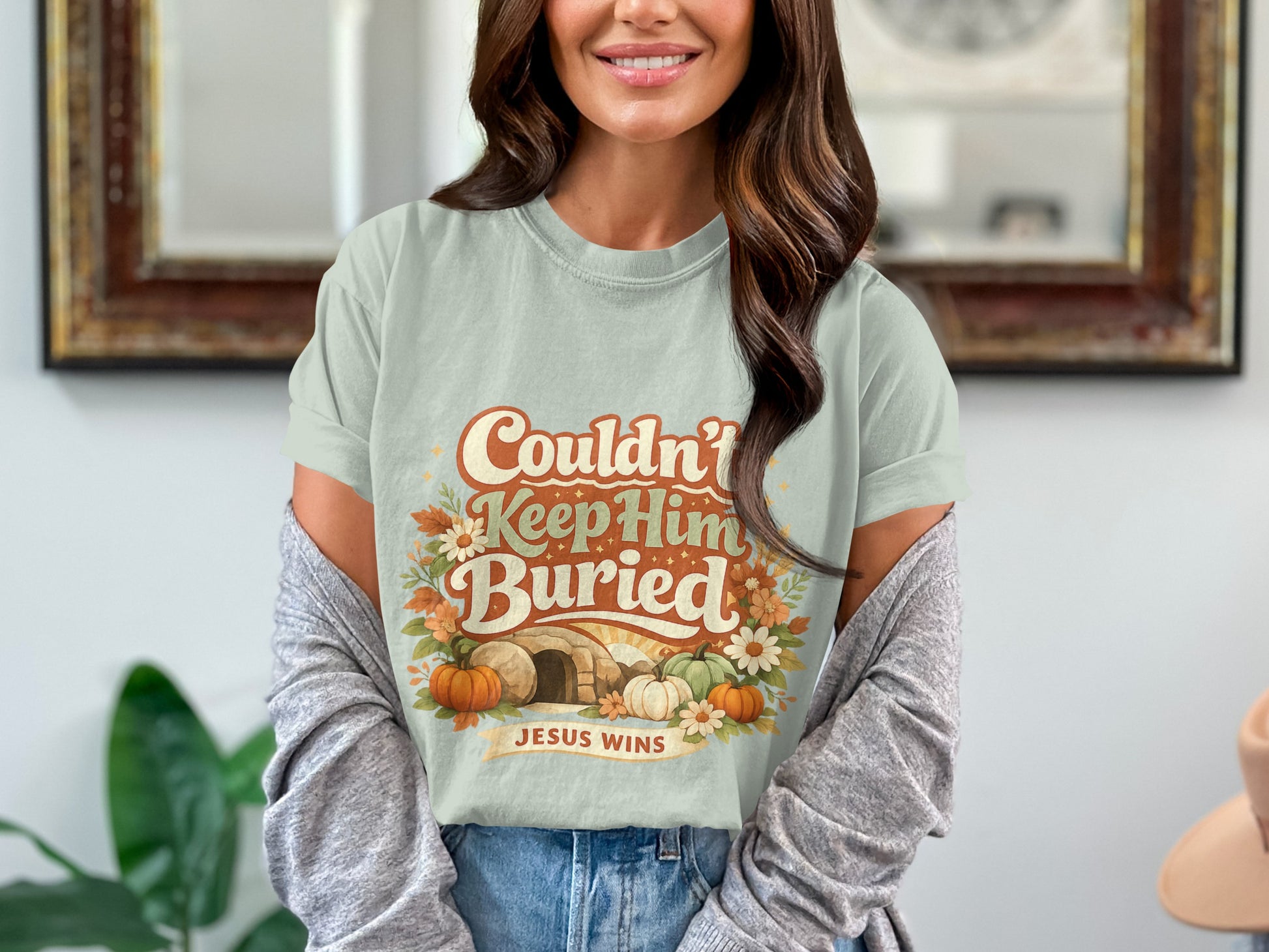 T-shirt with "Couldn't Keep Him Buried Jesus Wins" text and tomb graphic.
