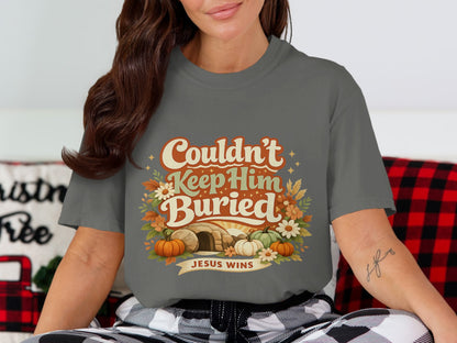 Gray t-shirt with "Couldn't Keep Him Buried" and "Jesus Wins" text, tomb, and pumpkins.