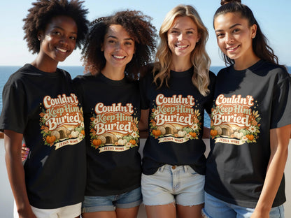 Four women smile wearing black t-shirts with "Couldn't Keep Him Buried" and "Jesus Wins" graphic.