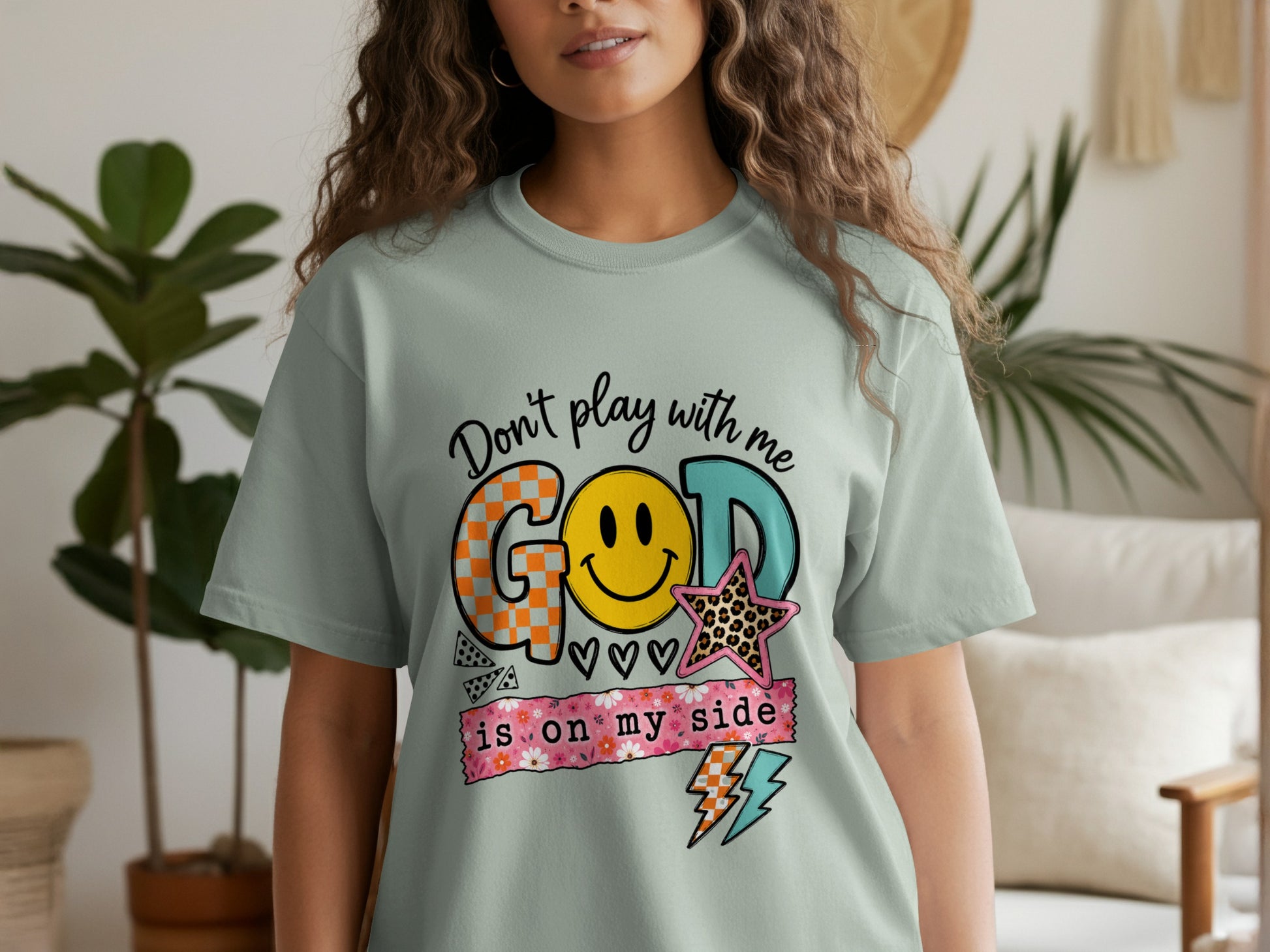 Light green t-shirt with "Don't play with me GOD is on my side" text and graphics.