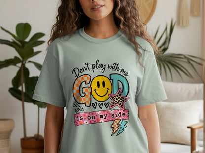 Light green t-shirt with "Don't play with me GOD is on my side" text and graphics.