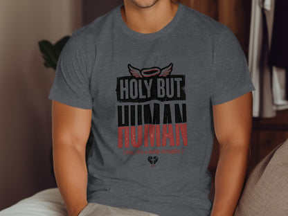 Dark grey t-shirt with text "HOLY BUT HUMAN" and small wings.