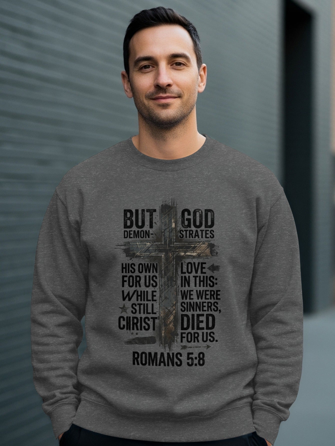 Dark gray sweatshirt with "But God" and Romans 5:8 Bible verse.