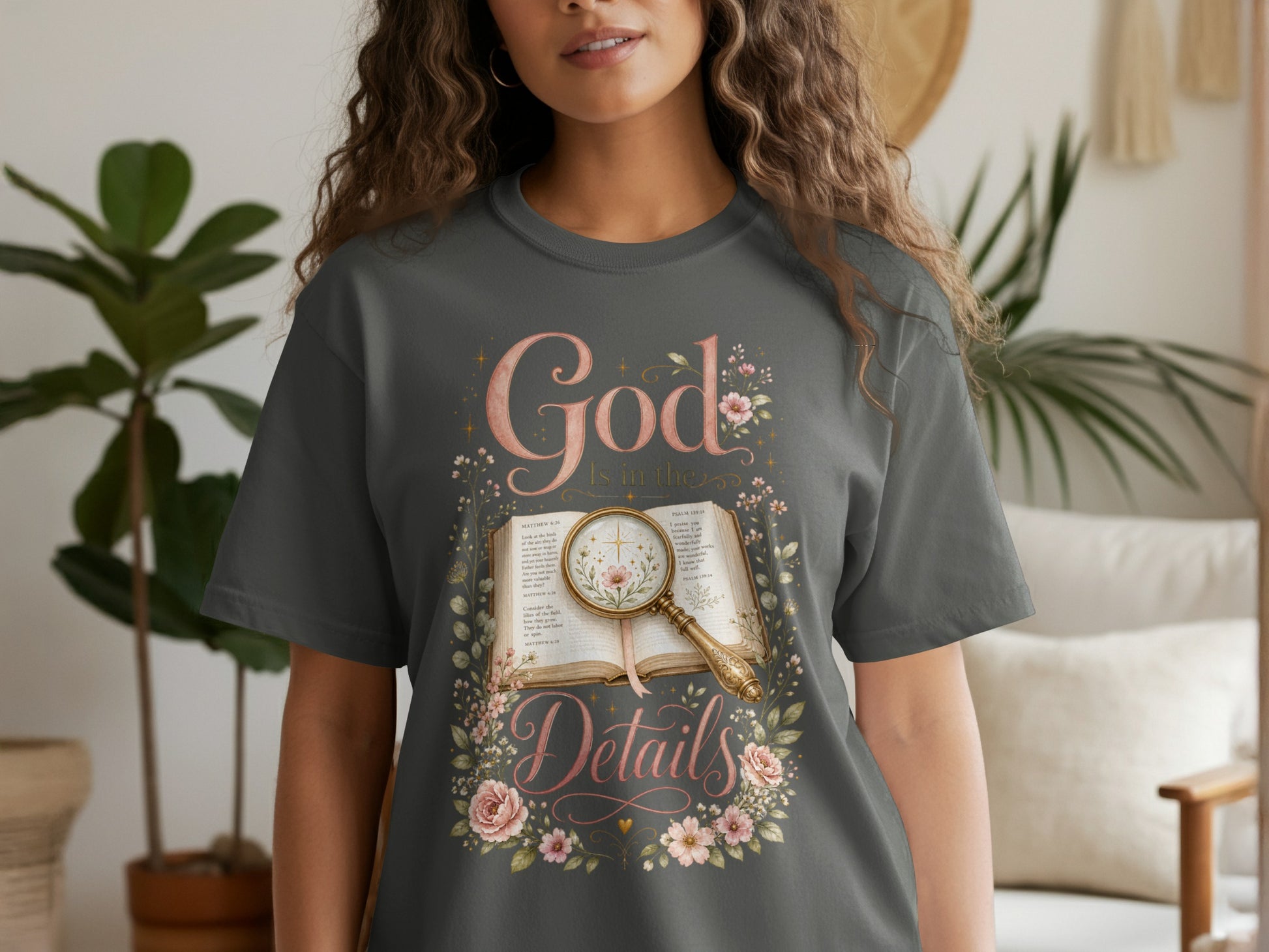 Dark gray t-shirt graphic with "God is in the Details" text and an open book.