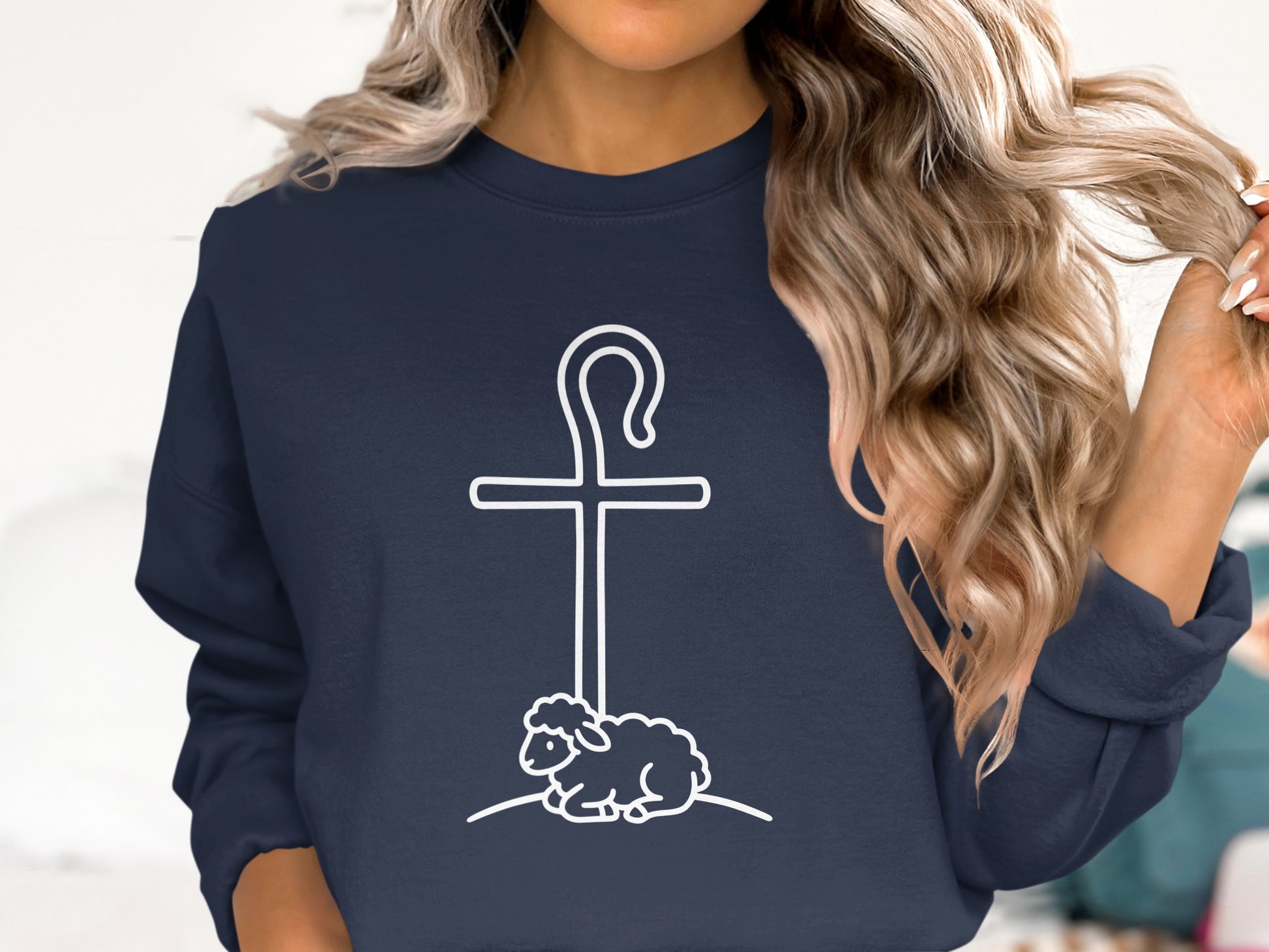 Navy sweatshirt with white cross, shepherd's crook, and sheep graphic.