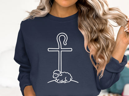 Navy sweatshirt with white cross, shepherd's crook, and sheep graphic.