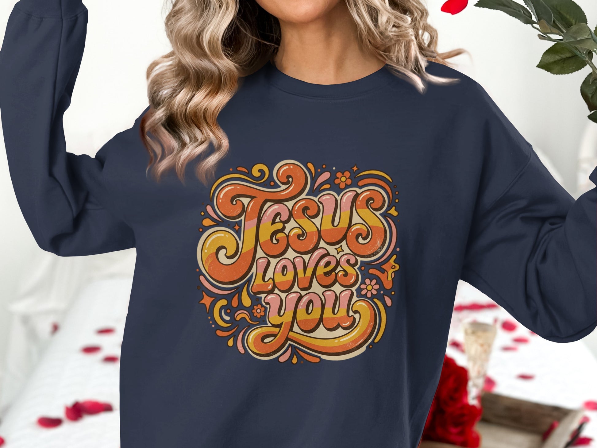 Navy sweatshirt with "Jesus Loves You" in retro orange, yellow, and pink lettering.