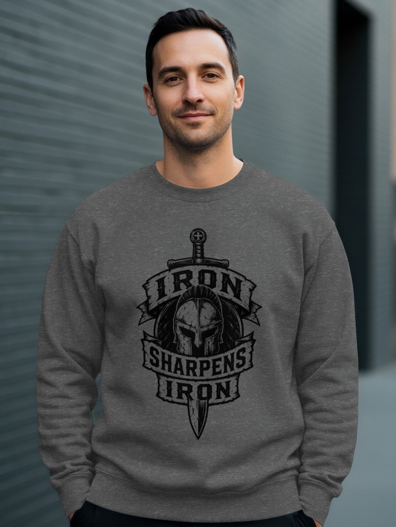 Man wearing gray sweatshirt with Iron Sharpens Iron logo.