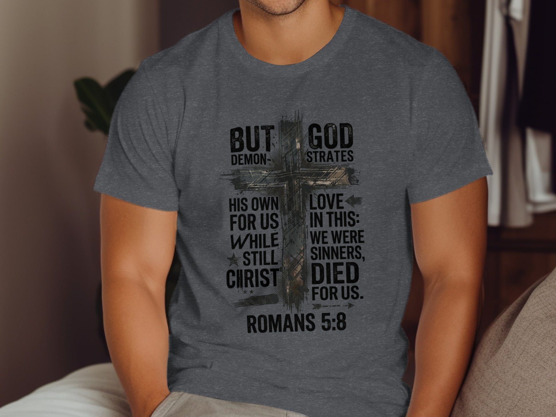 Dark grey t-shirt with "But God Demonstrates His Love" text and cross.