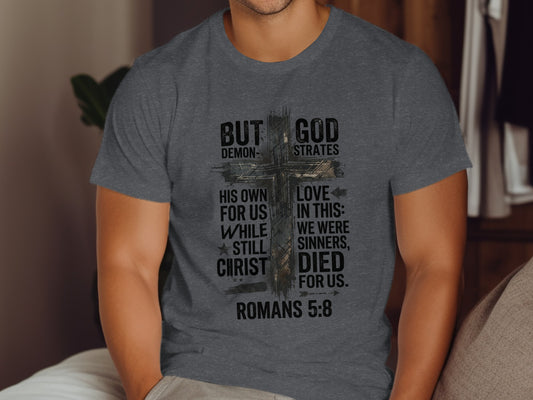 Dark grey t-shirt with "But God Demonstrates His Love" text and cross.