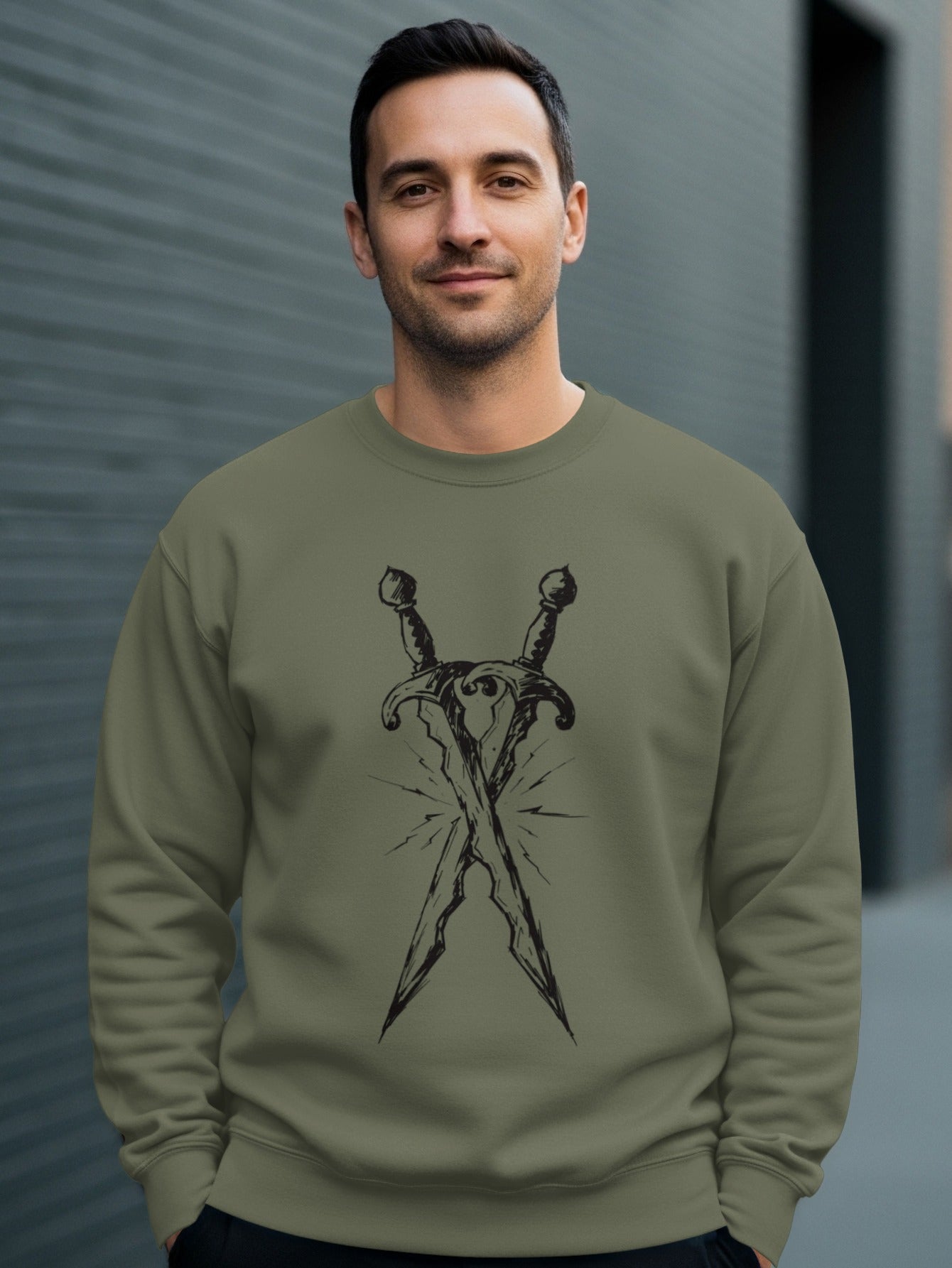 Man wearing olive green sweatshirt with crossed swords graphic.